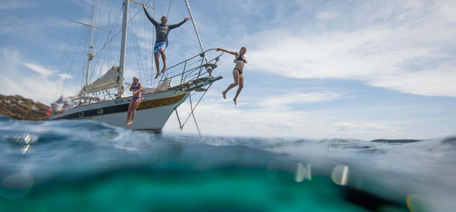 Guests jumping off the sailboat into Wineglass Bay