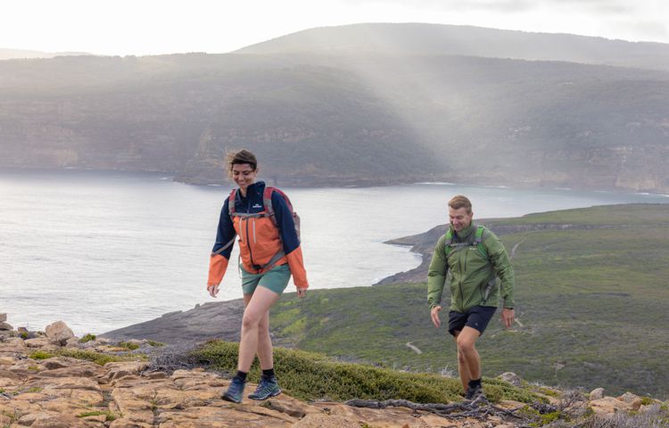 Guests walking along path with ocean behind them