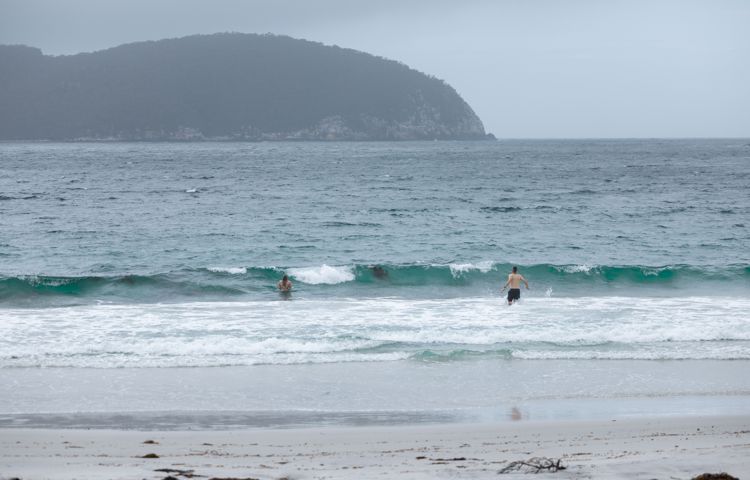 Guests swimming in Beach at Three Capes